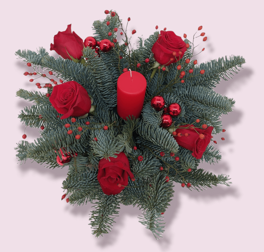 Centrotavola natalizio classico con candela e decorazioni rosse abete bacche e rose rosse fresche